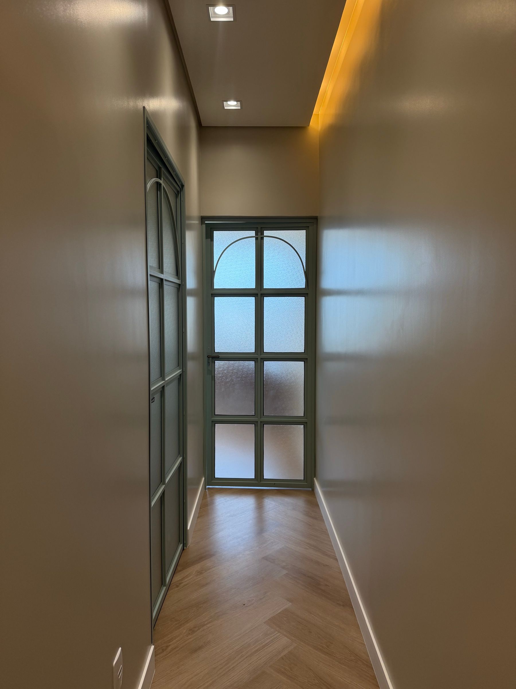 Corredor da Clínica Benvenuta com porta de vidro ao fundo