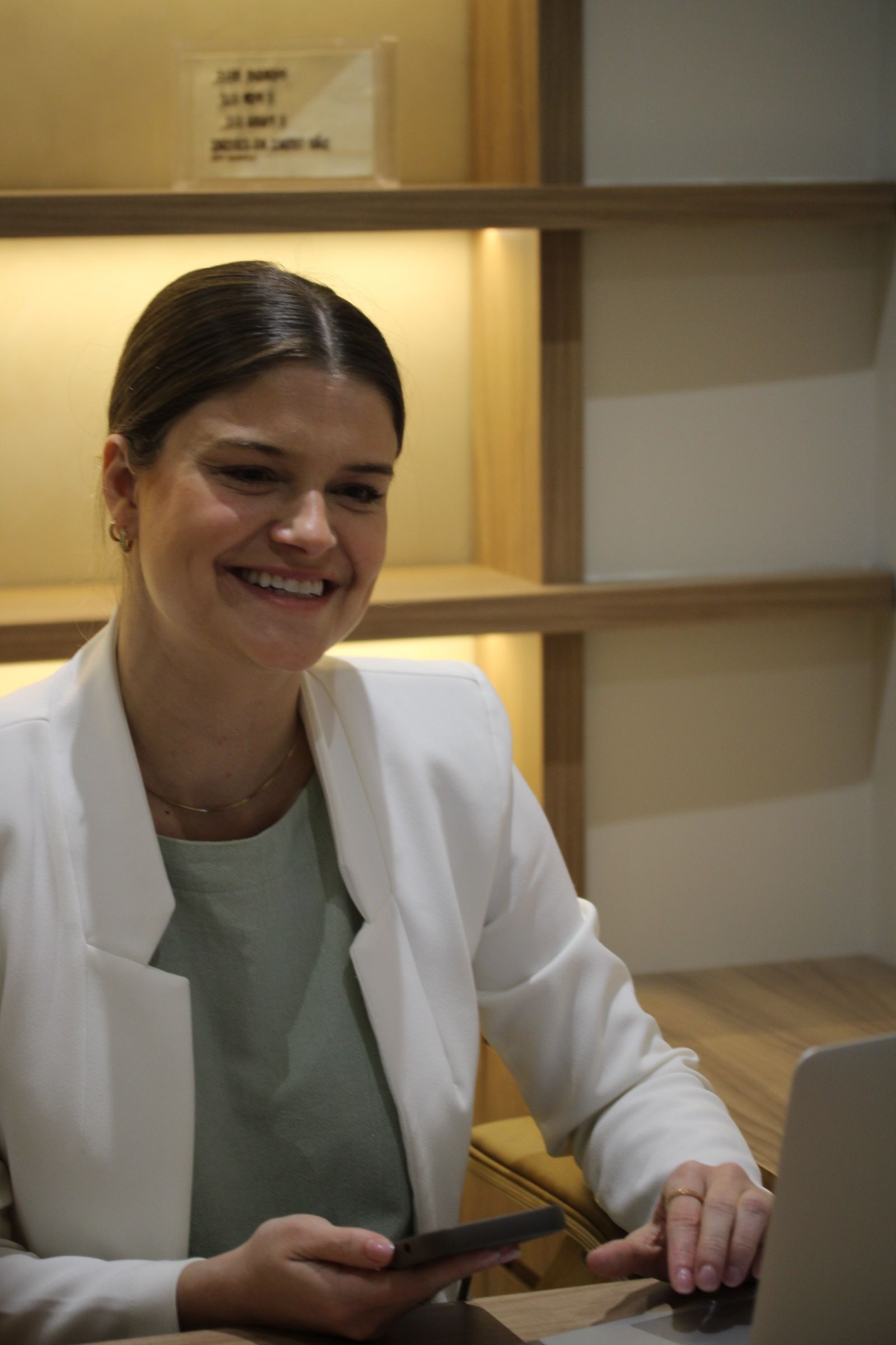 Dra. Louise Costa sorrindo em seu consultório