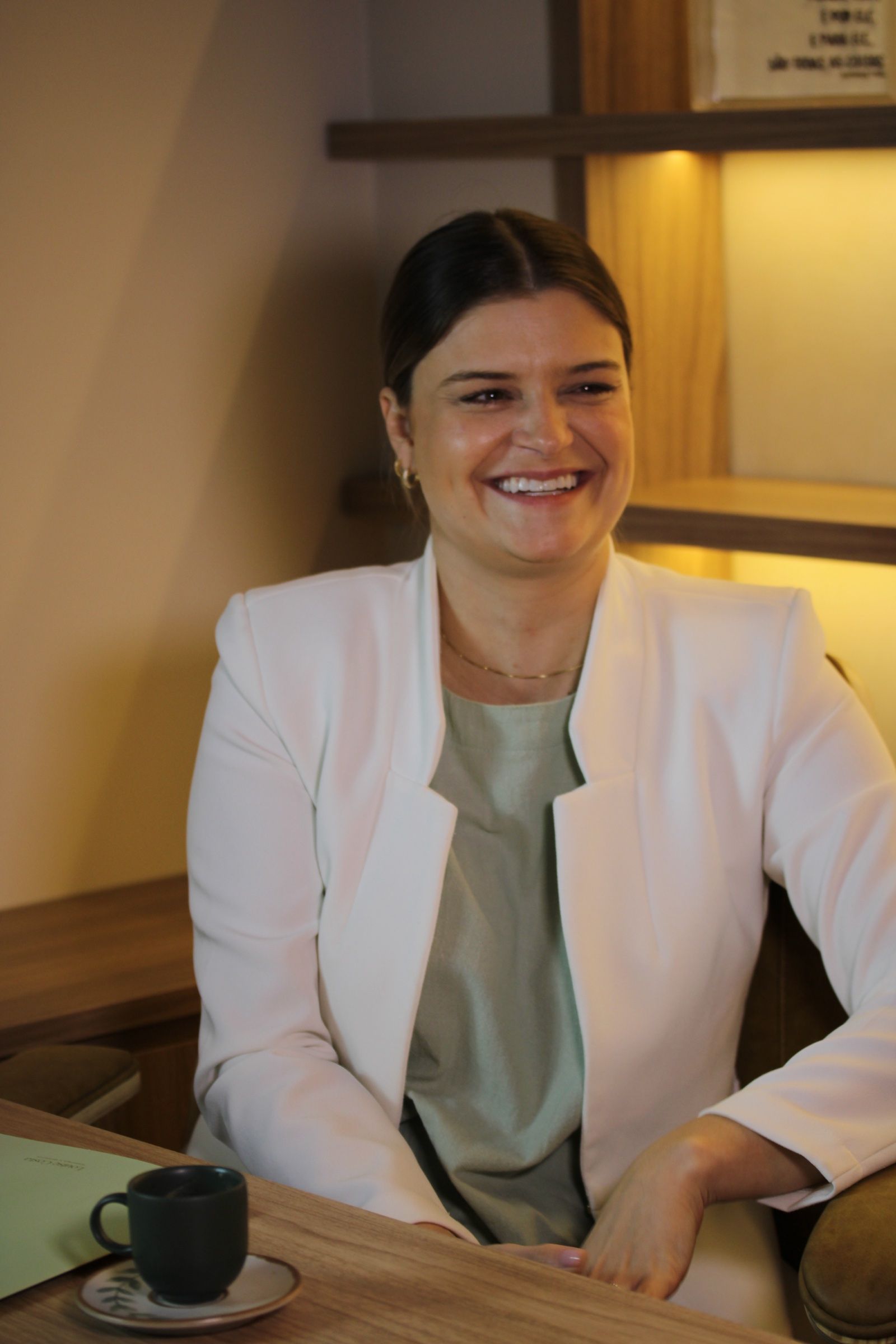 Dra. Louise Costa sorrindo em seu consultório na Clínica Benvenuta