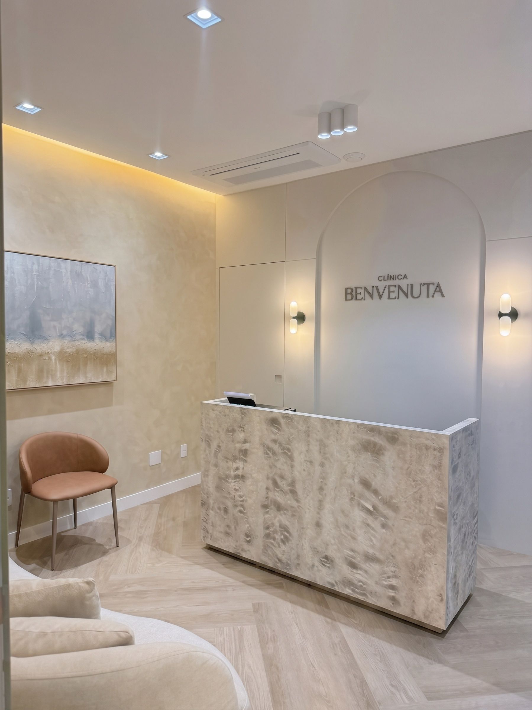 Balcão da recepção da Clínica Benvenuta, com o letreiro no arco ao fundo